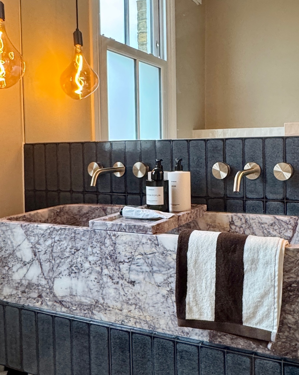 A double marble sink unit with dark zellige tiles and brushed brass pendants — Tooting Bec bathroom by Jewel Design Studio